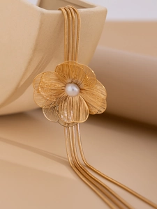 Détail d'une fleur en métal doré avec perle et élégants glands de chaînes serpent