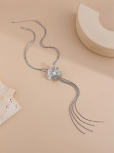 Détail macro du pendentif fleur argenté avec perle et élégantes pampilles en métal