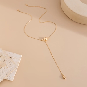 Detail of gold Y-shaped snake chain necklace featuring organic heart and teardrop pendant
