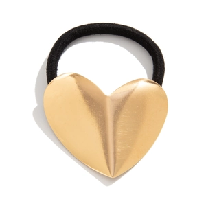 Minimalistisch haarelastiekje met getextureerd gouden hartje op een witte achtergrond