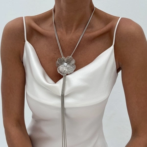 Collier fleur et perle à pampilles métalliques porté par un mannequin en robe de satin