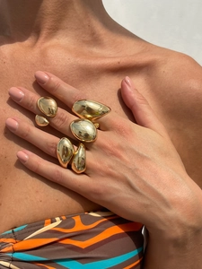 Dettaglio di anelli d'oro spessi dal design fluido indossati con uno stile di lusso
