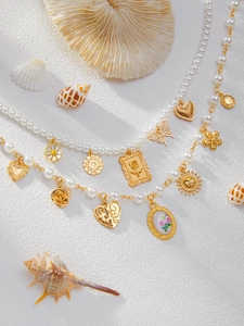Détail de colliers en perles bohèmes avec étoiles de mer, coquillages et breloques