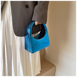 Gros plan d'un sac à main bleu métallique en acrylique au design géométrique et épuré
