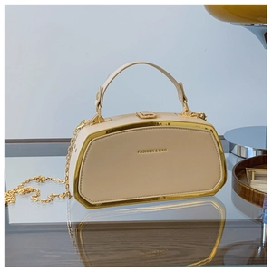 Dettaglio elegante borsa box beige con cornice dorata e scritta su superficie a specchio