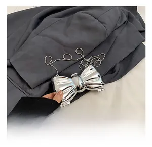 Close-up of silver butterfly acrylic evening bag with textured metallic finish and chain