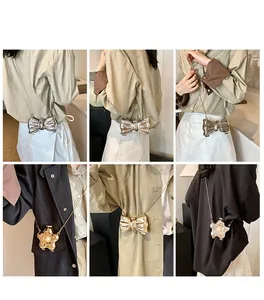 Detail view of mini butterfly and star metallic accessories with long chain on outfits