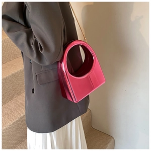 Détail du sac en acrylique rose fuchsia métallisé avec poignée ronde et chaîne dorée