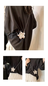 Detail of silver mirror flower bag with central pearl and elegant metal chain strap