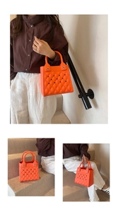 Detailansicht der leuchtend orangen EVA-Tasche mit Rautenmuster und Loch-Design