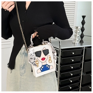 Detail der weißen Box-Clutch mit Pop-Art-Sonnenbrillen-Motiv und Seidenschal-Griff