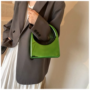 Détail du sac à main en acrylique vert métallisé avec poignée circulaire évidée chic