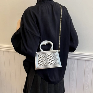 Silver metallic small square bag with textured V-waves, featuring top handle and chain strap