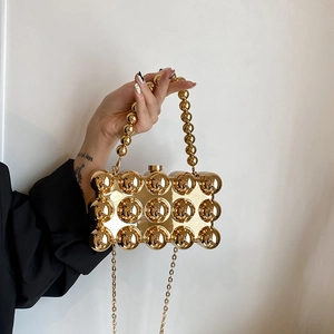 Golden spherical acrylic evening bag with metallic finish and beaded handle for women