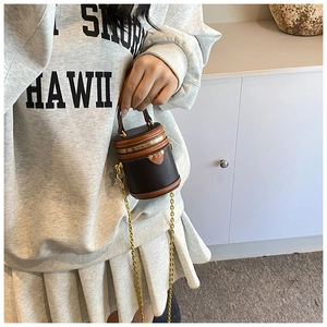Detail of mini bucket bag showing lychee pattern leather and gold metal chain strap