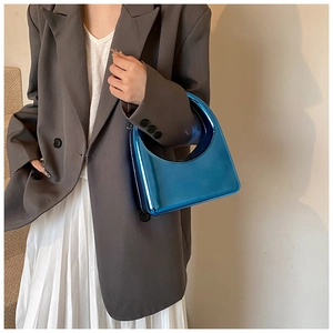 Gros plan d'un sac à main demi-lune bleu électrique métallique avec une finition miroir lisse