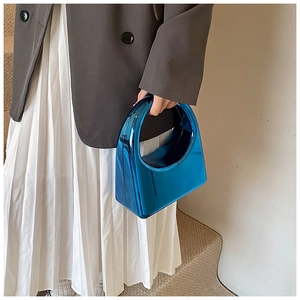 Détail du sac à main bleu en acrylique avec poignée ronde et fini miroir métallique