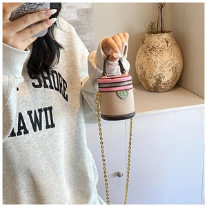 Close-up of tricolor mini bucket bag with leather texture and gold chain strap details