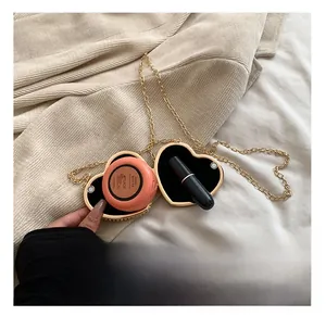 Detailed interior of heart shaped golden clutch showing capacity for lipstick and makeup