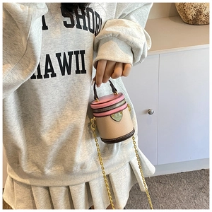 Detailed shot of mini cylinder crossbody bag with contrast colors and gold chain strap