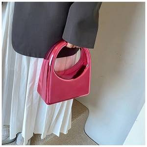 Vue détaillée du sac à main fuchsia effet miroir avec une poignée ovale minimaliste