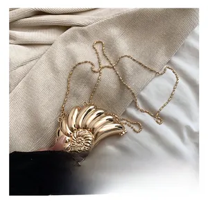 Dettaglio ravvicinato di una borsa da sera in metallo dorato a forma di nautilus con catena