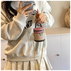 Detailed view of mini contrast bucket bag with pink lid and golden chain strap for women