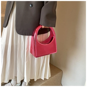 Détail du sac hobo rose métallique avec finition réfléchissante et poignée incurvée
