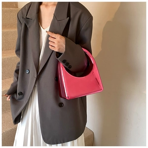 Sac à main en acrylique rose vif stylisé avec un blazer gris et une jupe plissée blanche