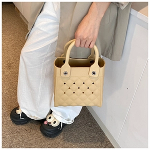 Detailansicht der beigen EVA-Tasche mit Rautenmuster und perforiertem Lochdesign