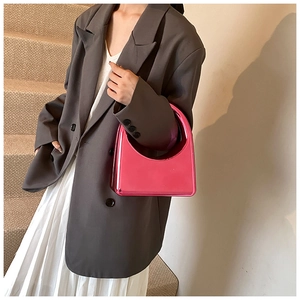 Gros plan d'un sac à main en acrylique rose métallisé avec poignée semi-circulaire