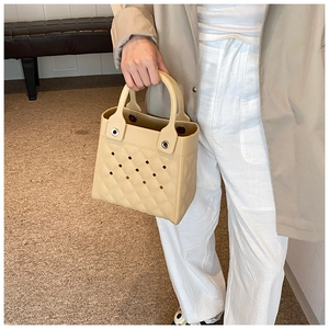 Mini-EVA-Tasche in Beige mit Rautenmuster und Lochdesign, präsentiert von einem Modell