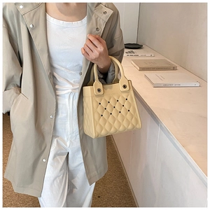 Detail der cremefarbenen EVA-Mini-Tasche mit schicken Gitter-Ausschnitten und Rundgriffen