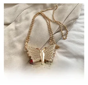 Détail d'un mini sac papillon en métal doré avec des strass étincelants de luxe