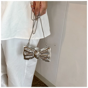 Detail of silver butterfly-shaped acrylic evening bag with a metallic chain strap