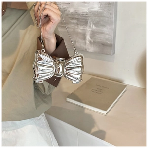 Silver bow-shaped acrylic evening bag with mirror finish and elegant metal chain strap
