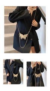 Détail d'un mini sac papillon en métal doré avec motifs ajourés et chaîne à billes