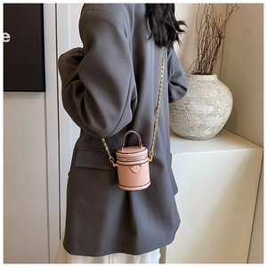 Detail view of pink mini bucket bag with textured leather and heart metal ornament