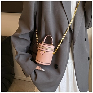 Detail of pink mini bucket bag with lychee grain leather and golden chain strap