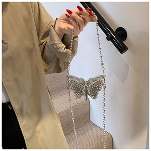 Vue détaillée du mini sac papillon argenté scintillant avec une texture de strass fins