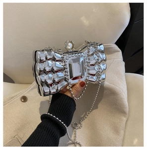 Detail of silver bow clutch with quilted metallic texture and pearl rhinestone clasp