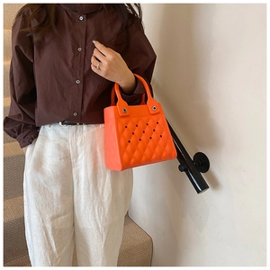 Detail der leuchtend orangefarbenen EVA-Mini-Tasche mit schickem Rauten-Ausschnittmuster