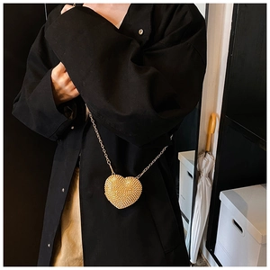 Detailed view of heart-shaped mini crossbody bag with gold rhinestones and chain strap