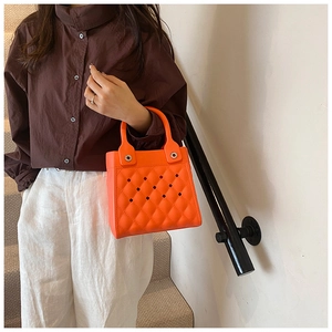 Detail der leuchtend orangefarbenen EVA-Strandtasche mit Rautenmuster und Ausschnitten