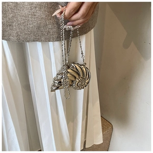 Dettaglio di una mini borsa a conchiglia argento metallizzato con catena a sfere