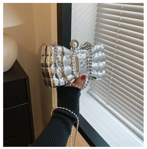 Detail of silver metallic butterfly evening bag with pearl clasp and bead chain strap
