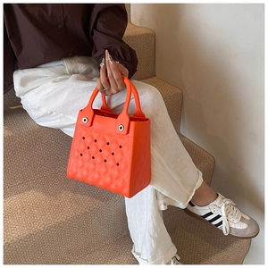 Detail der leuchtend orangefarbenen EVA-Tasche mit Rautensteppung und Lochmuster-Akzenten