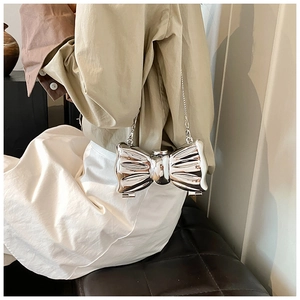 Detail of silver metallic butterfly bow clutch bag with thin chain strap for evening