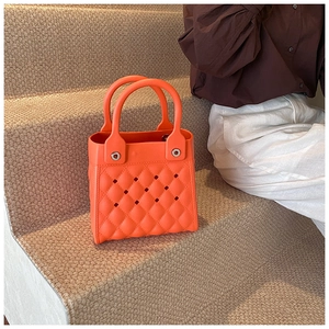 Detail einer orangefarbenen EVA-Tasche mit hohlem Rautengitter und silbernen Nieten