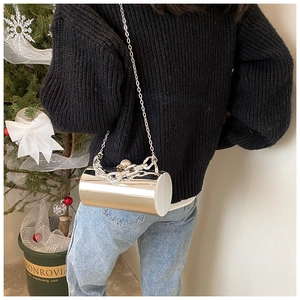 Silver mirror patent leather bucket bag with chain strap shown on a model